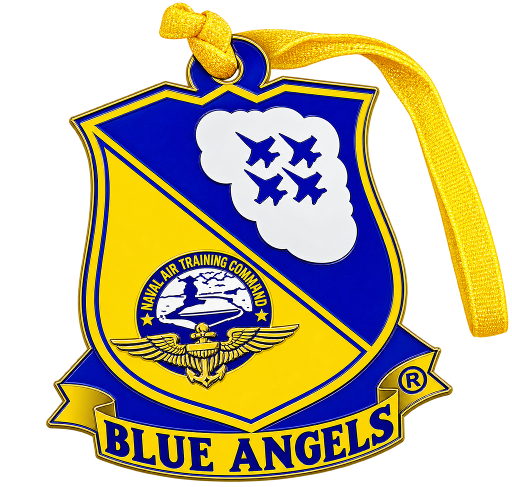 A Blue Angels commemorative ornament shaped like a military crest, featuring a yellow and blue shield design with four jets in a cloud, an eagle emblem, and a yellow ribbon hanging from the top.